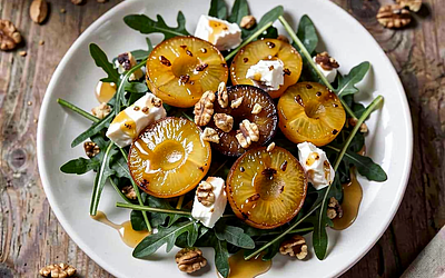 Arugula salad with goat cheese and roasted mirabelle plums, honey-horseradish vinaigrette