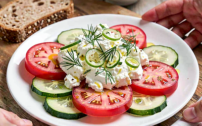 Salad with raspberry tomatoes and lightly salted cucumber with cottage cheese and dill