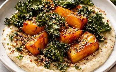 Roasted butternut squash on roasted cauliflower cream with toasted quinoa and kale chips