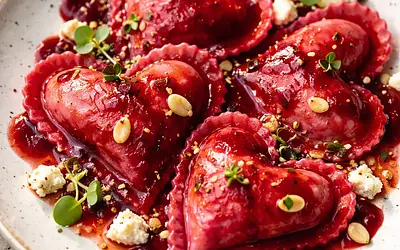 Beetroot ravioli with creamy ricotta and goat cheese filling, roasted beetroot and pomegranate sauce