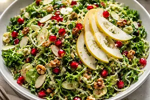Seasonal salad with thinly sliced Brussels sprouts, kale, and pears with pomegranate and nuts