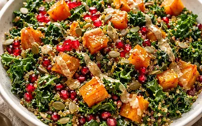 Fusion salad with roasted butternut squash, kale, quinoa, and pomegranate with miso-lemon dressing