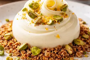 White chocolate mousse with a hint of orange on an oat-almond crumble with roasted pistachios